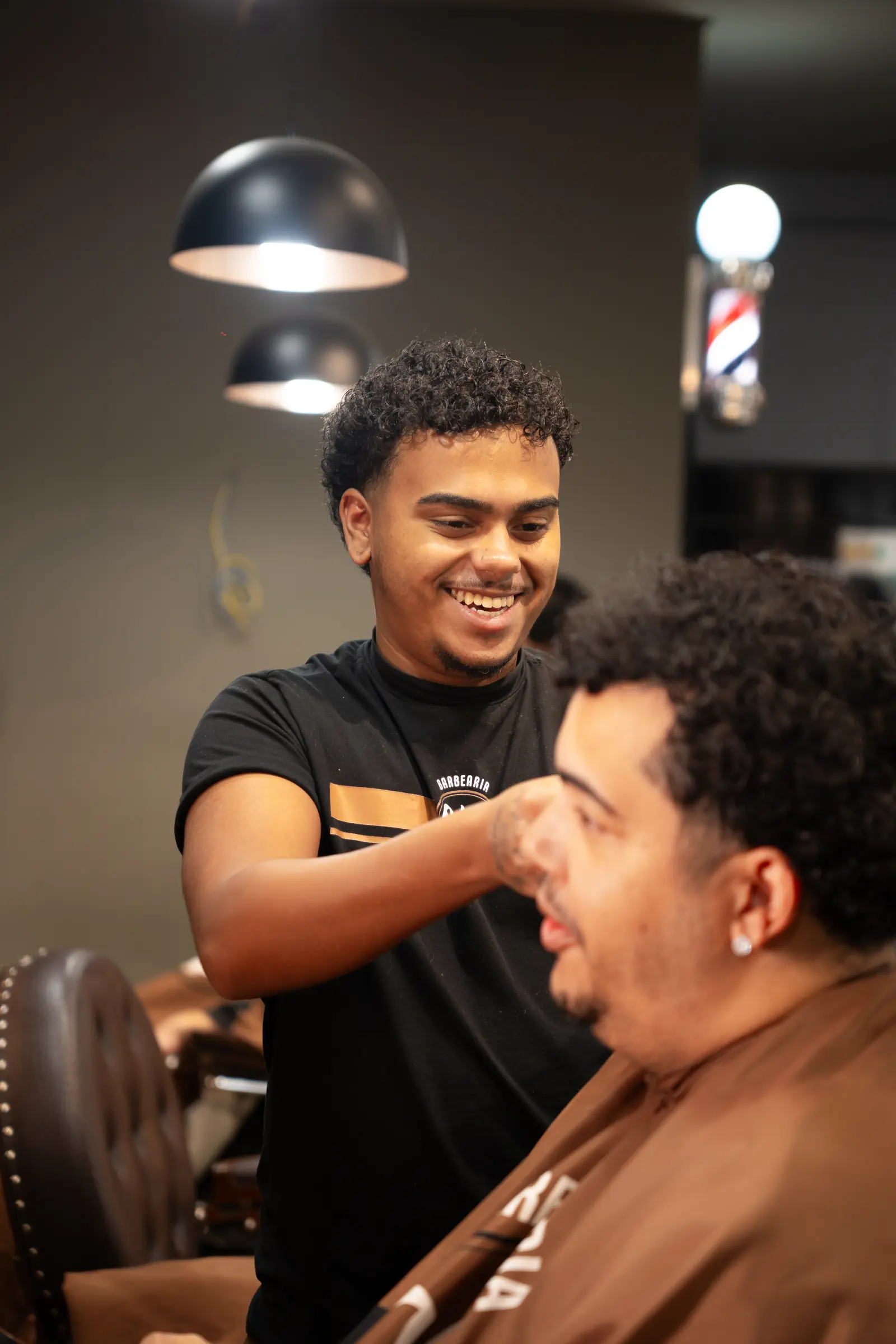 Barbeiro da Cleto sorrindo enquanto atende um cliente
